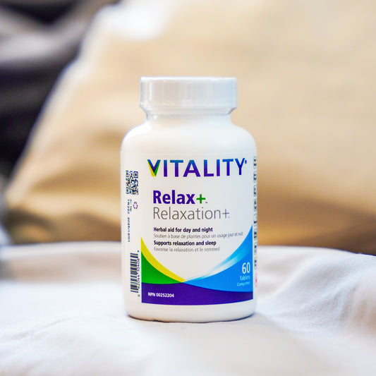 A bottle of VITALITY Relax+ Relaxation supplement on a surface with a blurred background.